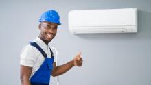 Technician Giving A Thumbs Up In Front Of A Mini-Split Heat Pump